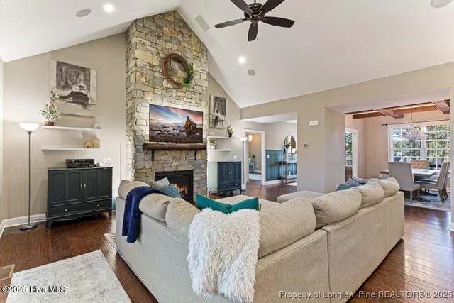 a kitchen with stainless steel appliances granite countertop a stove a refrigerator a kitchen island a sink and white cabinets with wooden floor