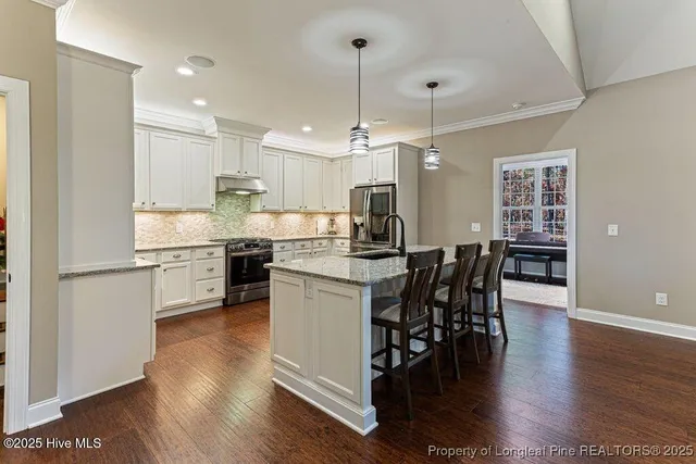 a kitchen with granite countertop white cabinets and stainless steel appliances
