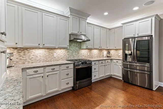 a kitchen with granite countertop a sink stainless steel appliances and cabinets