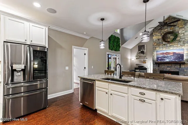 a open kitchen with stainless steel appliances granite countertop a stove cabinets and wooden floor