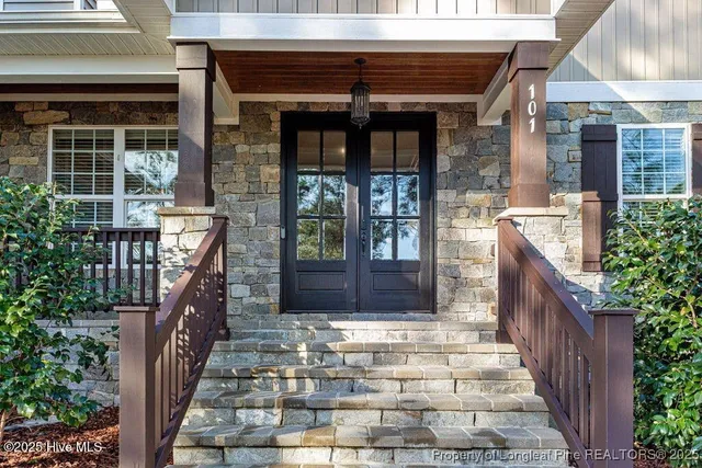 a view of a patio with table and chairs and floor to ceiling window with wooden fence