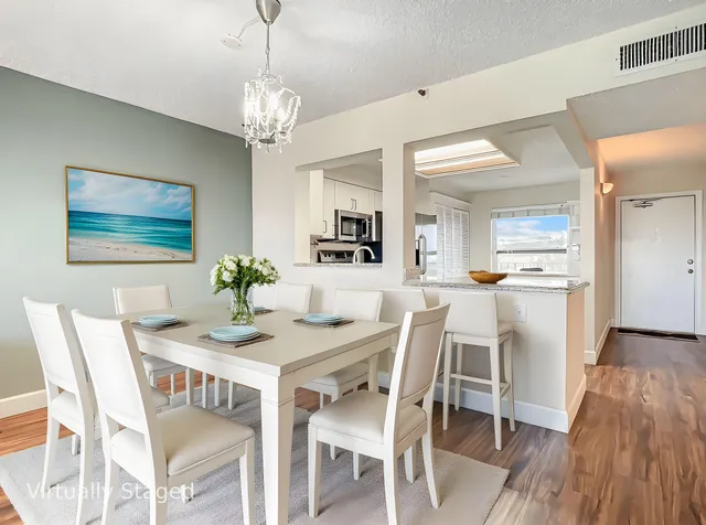 a dining room with furniture a chandelier and wooden floor