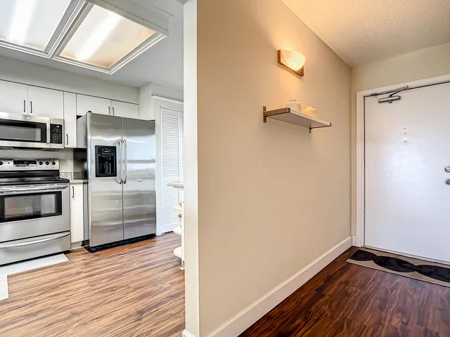 a view of kitchen with wooden floor and electronic appliances
