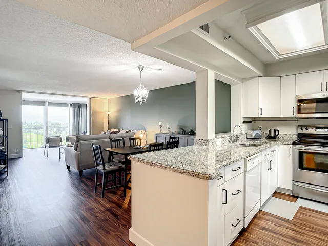 a kitchen with sink a stove and chairs