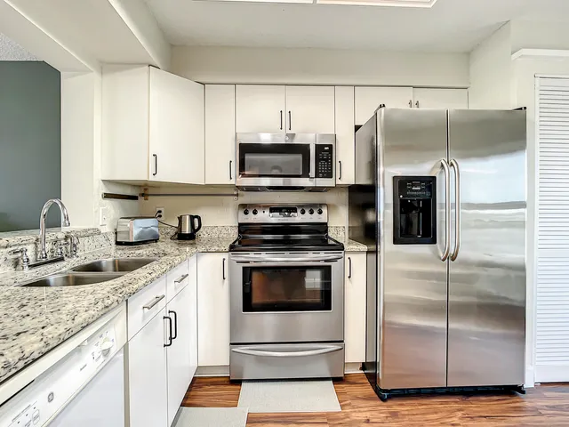 a kitchen with stainless steel appliances granite countertop a stove a refrigerator and a sink