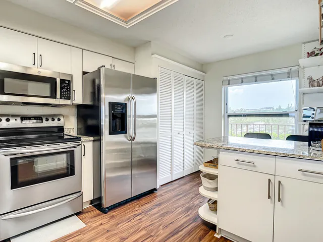 a kitchen with stainless steel appliances a stove a sink and a microwave