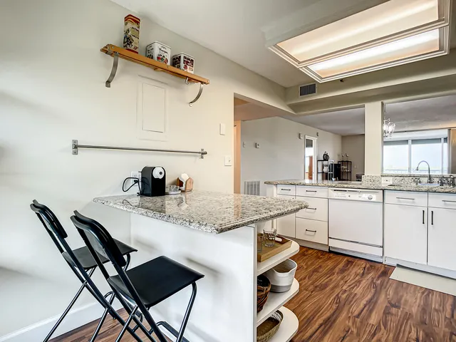 a kitchen with granite countertop white cabinets and appliances