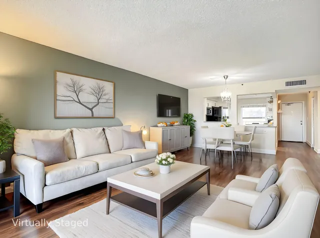 a living room with furniture kitchen view and a flat screen tv