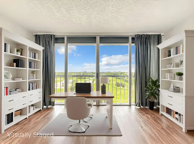 a living room with furniture large window and wooden floor