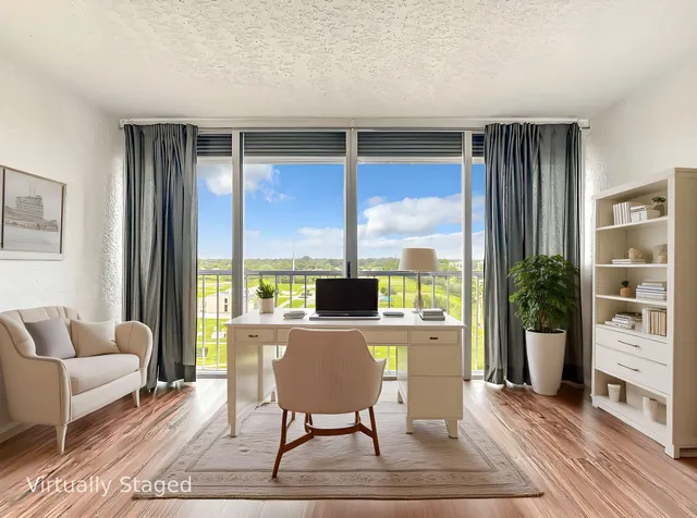 a living room with furniture large window and wooden floor