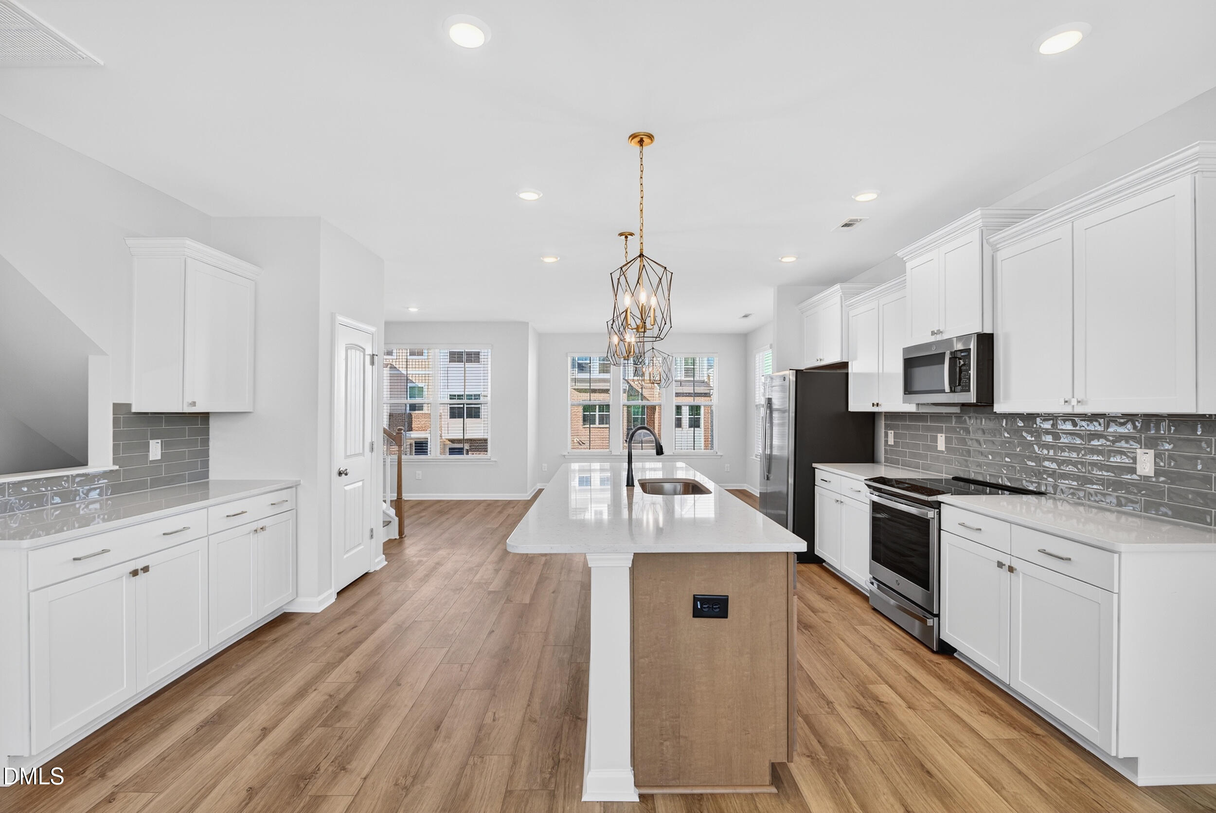 335 Chesapeake Commons Street Garner, NC 27529 - Photo 5 of 20 a large kitchen with granite countertop a large counter top a sink stainless steel appliances and cabinets