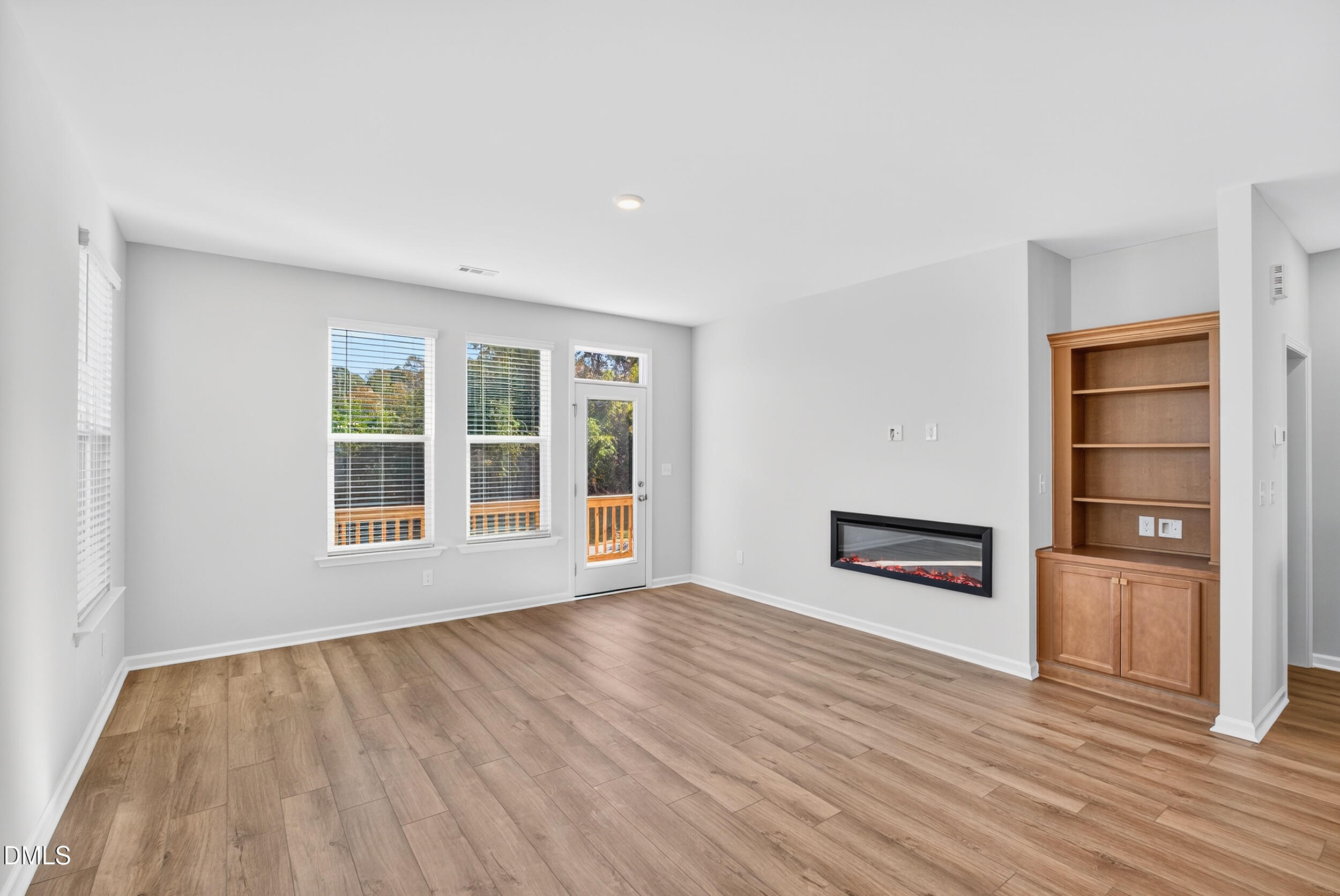 335 Chesapeake Commons Street Garner, NC 27529 - Photo 8 of 20 a view of an empty room with a window and wooden floor