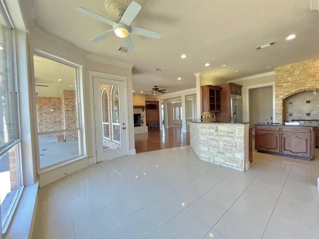 a large hall with stainless steel appliances a large kitchen island and a couch