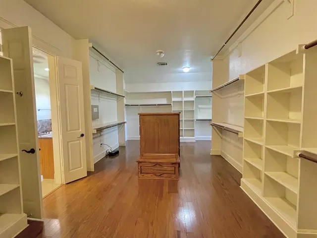 a view of walk in closet with wooden floor