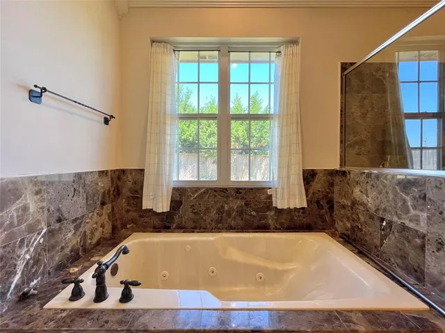 a bathroom with a bathtub and a window