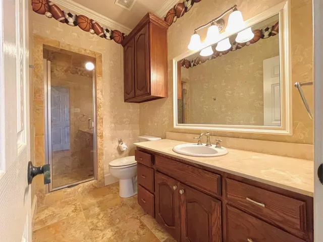 a bathroom with a granite countertop sink toilet and shower