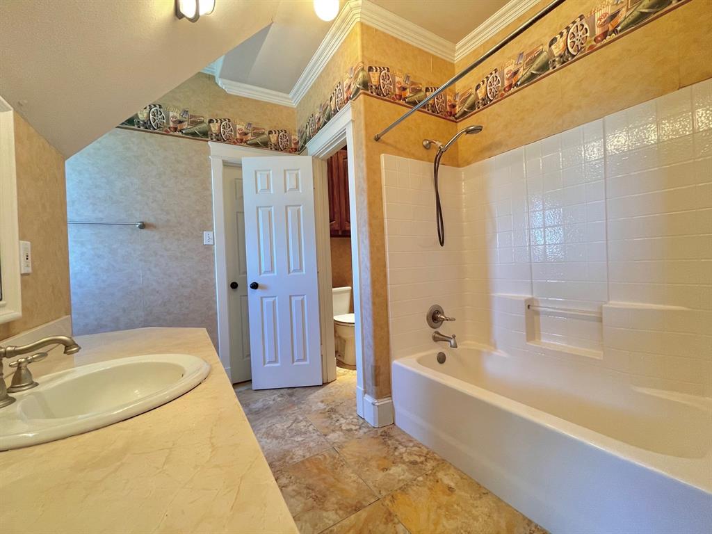 4026 Howard Road Waxahachie, TX 75165 - Photo 29 of 37 a spacious bathroom with a granite countertop sink a mirror a bathtub and shower