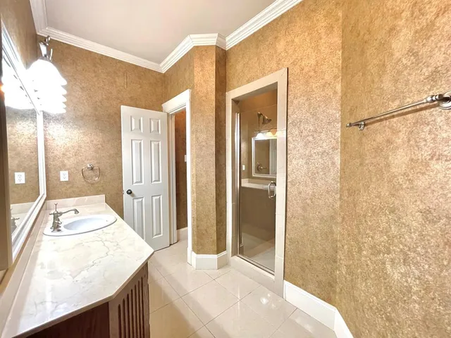a bathroom with a granite countertop sink a mirror and shower