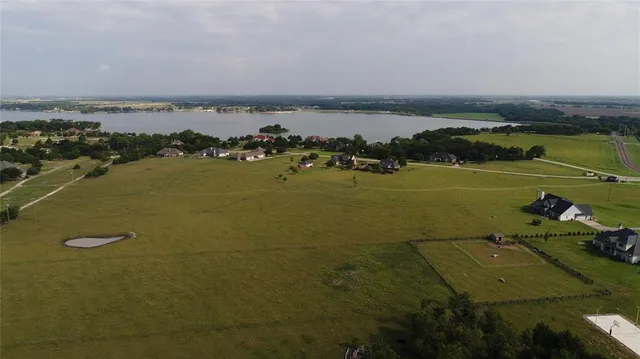 an aerial view of ocean and residential houses with outdoor space
