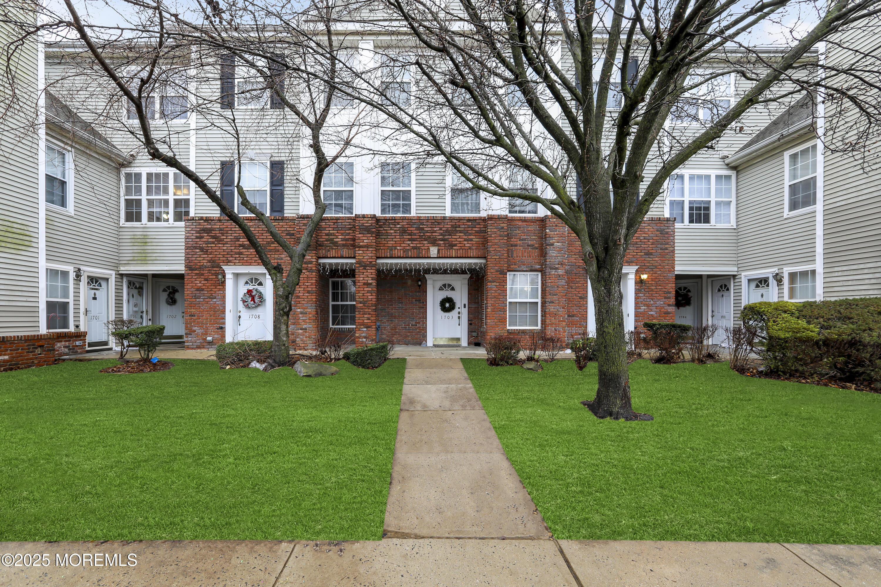 a front view of a house with a garden and trees