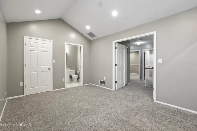 an empty room with closet and a bathroom