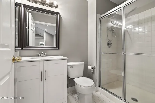 a bathroom with a shower sink vanity and toilet