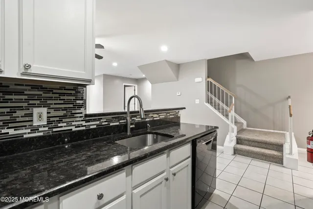 a kitchen with granite countertop a sink and cabinets