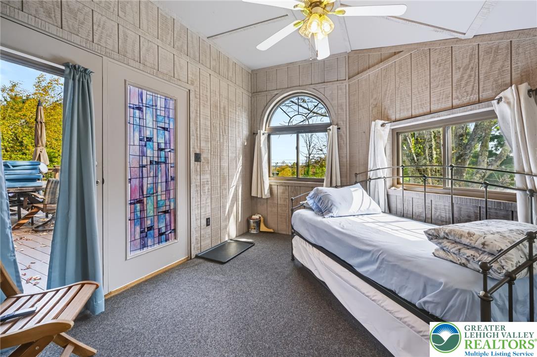 1605 Ridgeview Drive Lake Ariel, PA 18436 - Photo 14 of 40 Rustic wood-paneled walls and a vaulted ceiling frame this inviting bedroom with deck access.