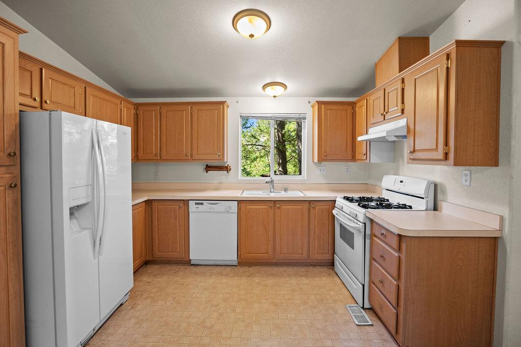 1281 Pleasant Valley Road, Unit 44 Diamond Springs, CA 95619 - Photo 9 of 27 a kitchen with stainless steel appliances granite countertop a refrigerator sink and stove