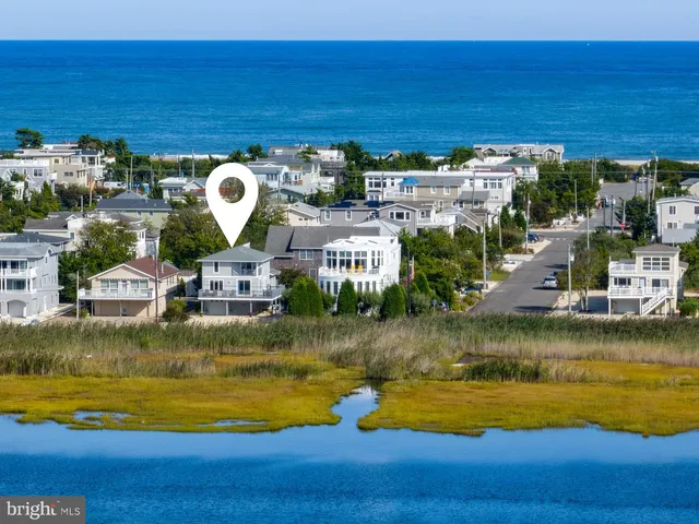 a front view of a house with a wooden deck and furniture