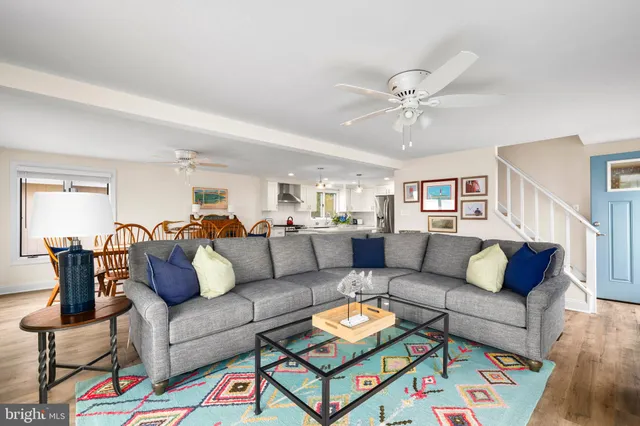 a view of a hallway with wooden floor and a living room