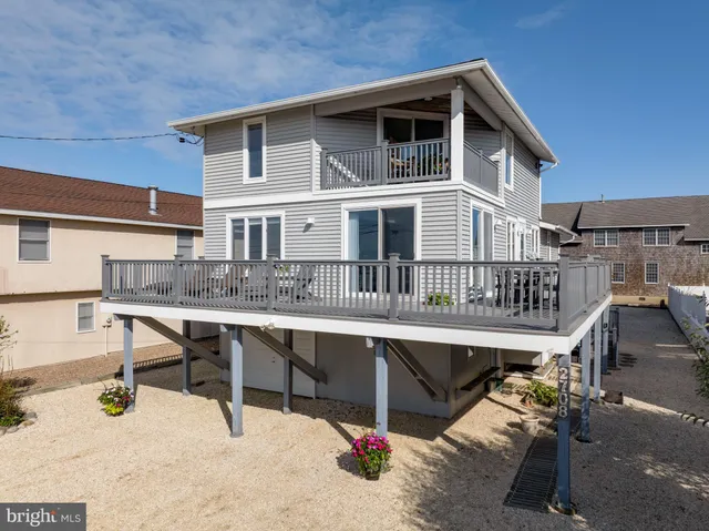 a balcony with wooden floor table and chairs