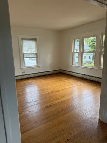 a view of a room with wooden floor and window