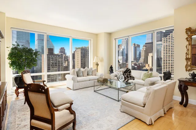 a living room with furniture a flat screen tv and a floor to ceiling window
