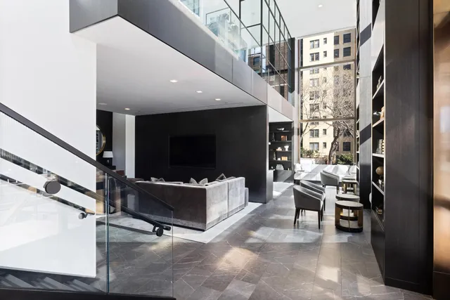 a living room with furniture a flat screen tv and kitchen view