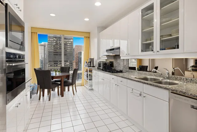 a living room with furniture a fireplace and a dining table with wooden floor