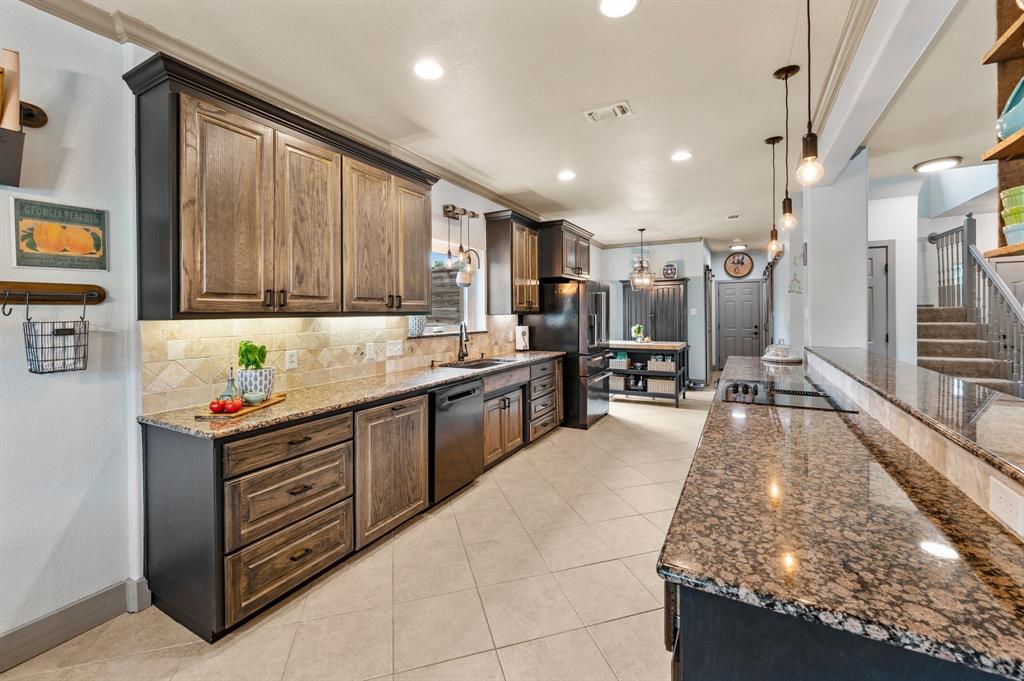 508 Chandler Road Keller, TX 76248 - Photo 8 of 39 a kitchen with stainless steel appliances granite countertop a stove top oven a sink dishwasher and cabinets with wooden floor