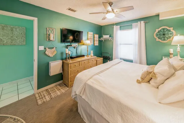 a bedroom with a bed mirror and a window