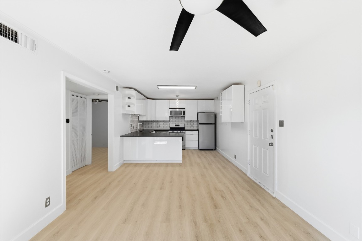 1304 Summit Street, Unit 102 Austin, TX 78741 - Photo 13 of 20 a kitchen with stainless steel appliances kitchen island a refrigerator and a stove top oven