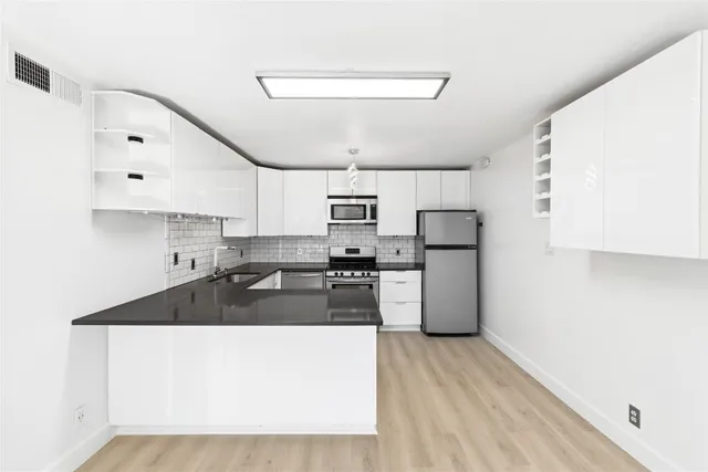 a kitchen with refrigerator and cabinets