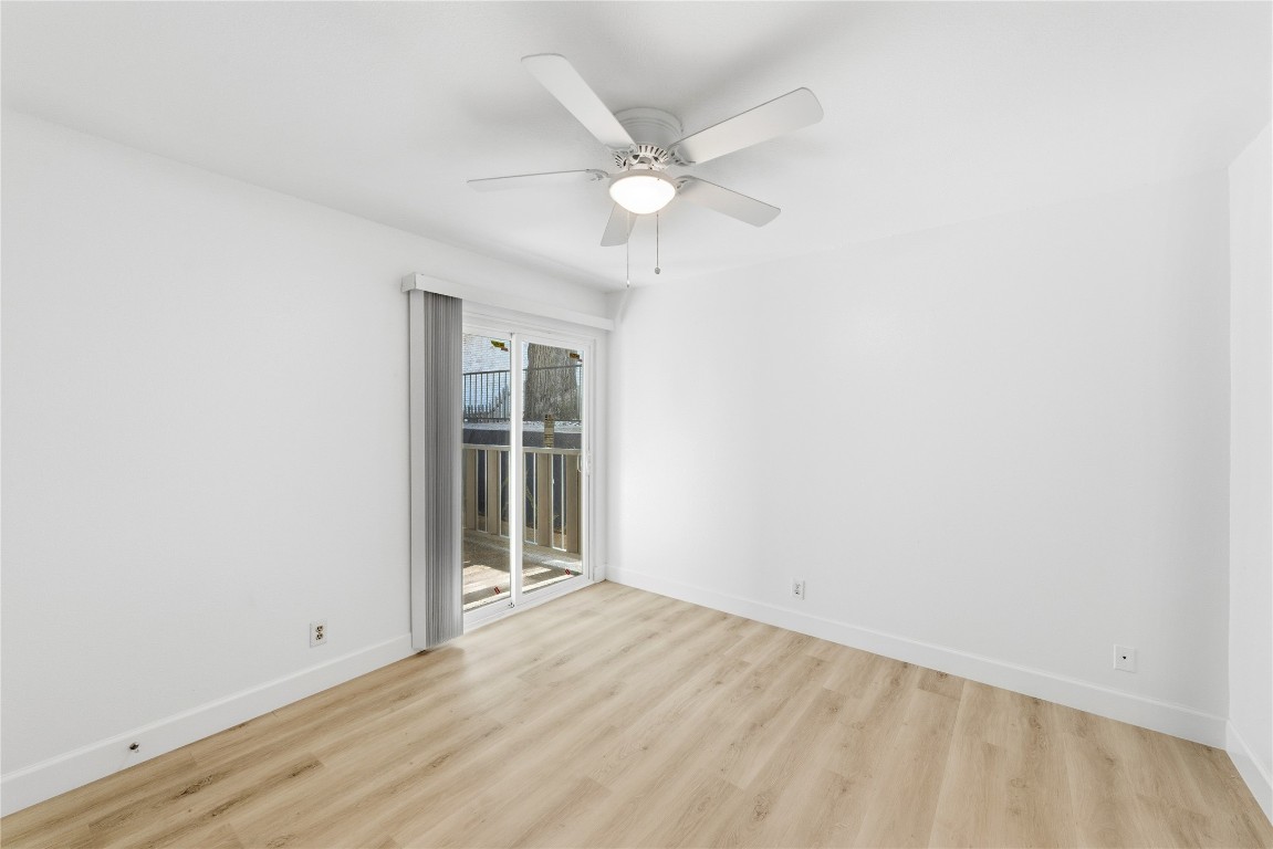 1304 Summit Street, Unit 102 Austin, TX 78741 - Photo 5 of 20 an empty room with a ceiling fan and window