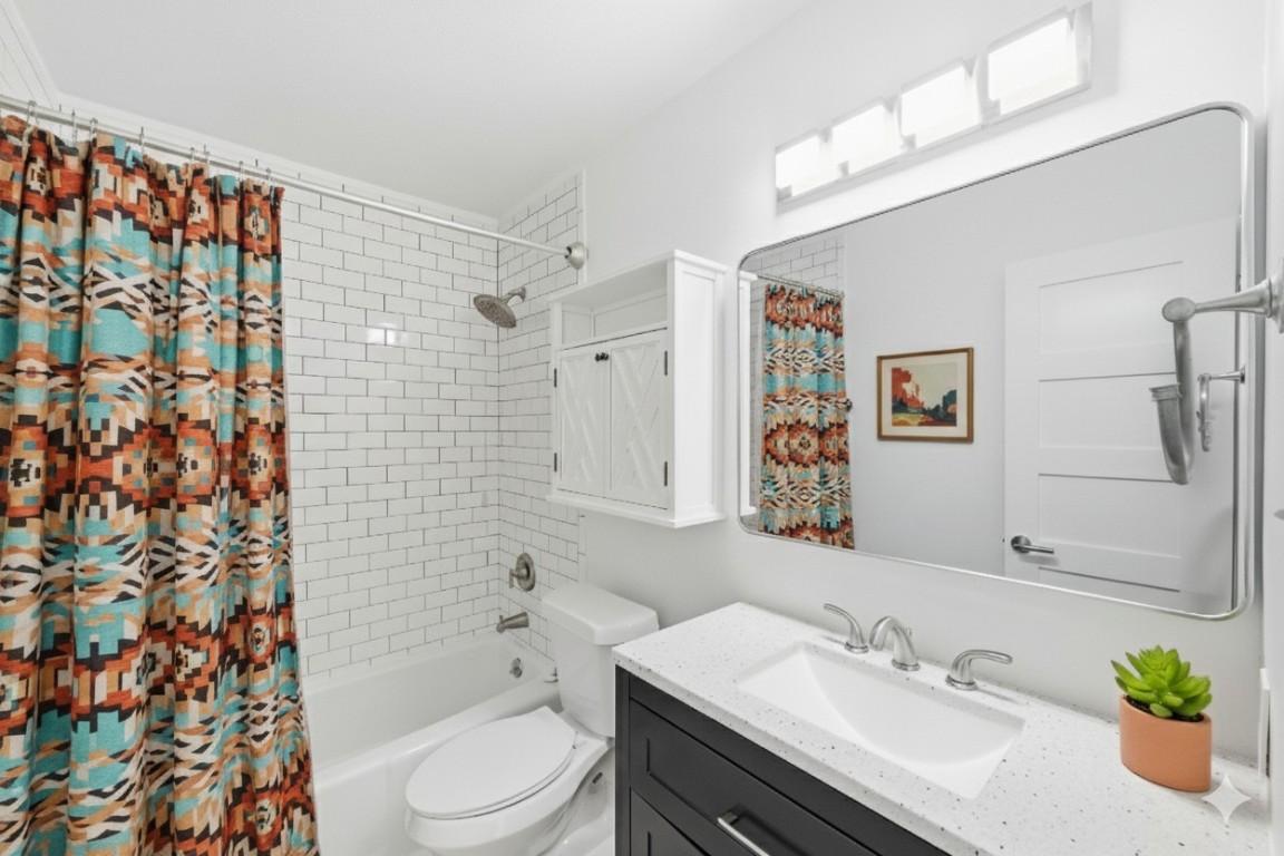 1304 Summit Street, Unit 102 Austin, TX 78741 - Photo 10 of 20 a bathroom with a sink a toilet and shower curtain