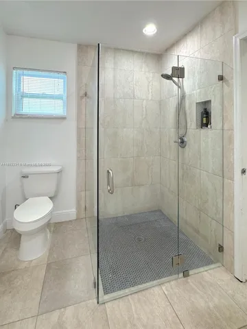 a bathroom with a shower a toilet and a sink