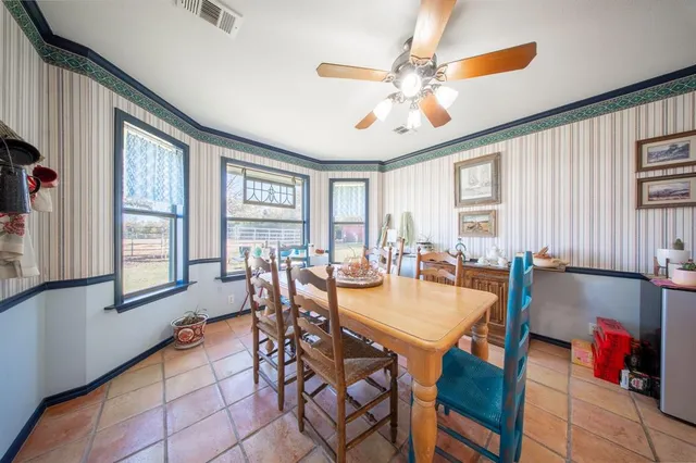 a dining hall with stainless steel appliances kitchen island granite countertop furniture and a large window