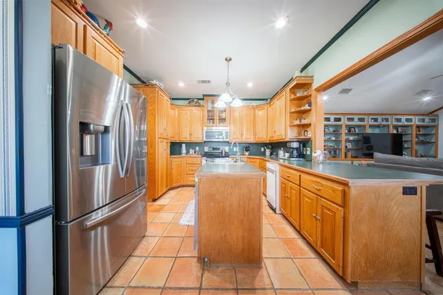a large kitchen with stainless steel appliances granite countertop a large window and a counter top space