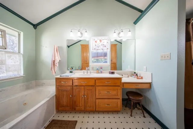a bathroom with a tub sink and mirror
