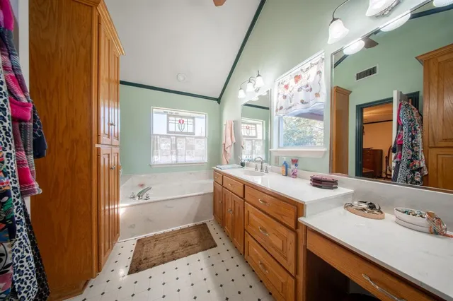 a bathroom with a sink a toilet a mirror and shower