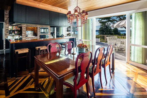 a view of a house with wooden deck and seating space