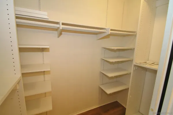 a view of walk in closet with empty racks