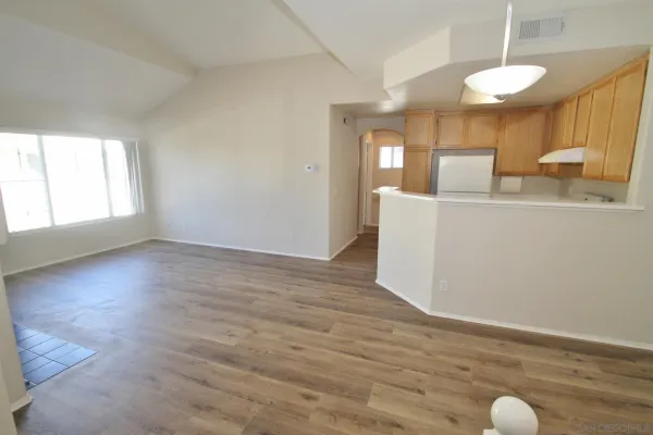 a view of kitchen and hall with wooden floor